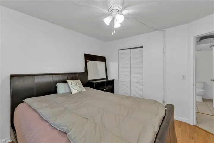 Bedroom featuring a closet, light wood-style flooring, ceiling fan, and baseboards
