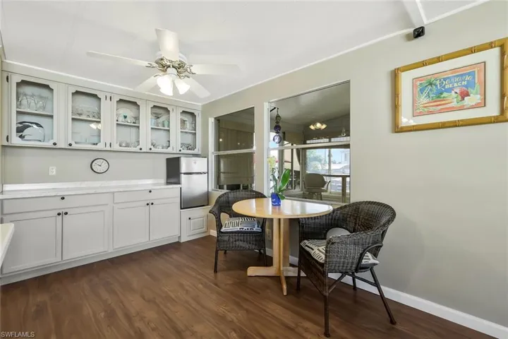 Dining room featuring dark wood-style floors, baseboards, and ceiling fan