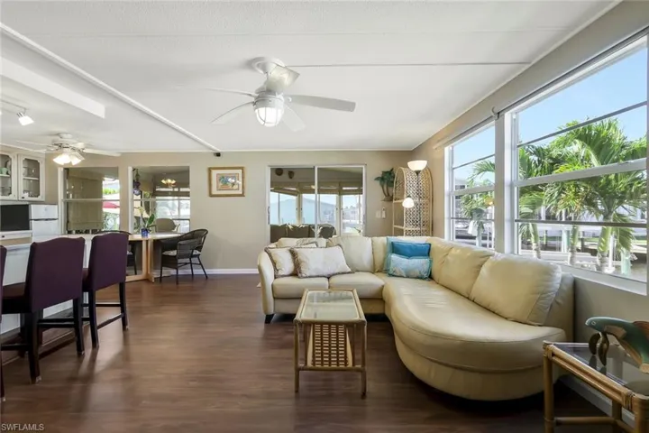 Living room featuring baseboards, dark wood-style floors, and ceiling fan