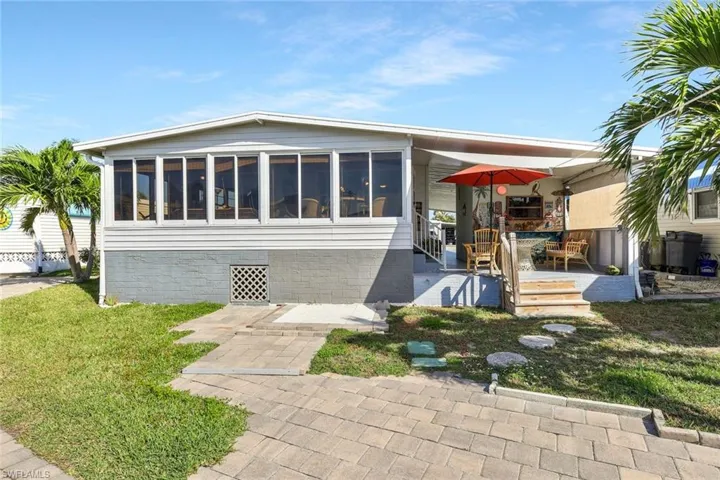 View of front of property featuring a front yard and a sunroom