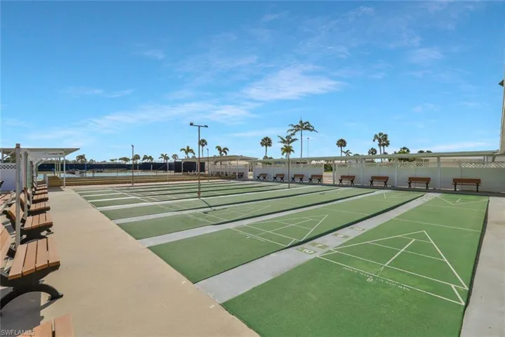 View of home's community featuring shuffleboard and fence