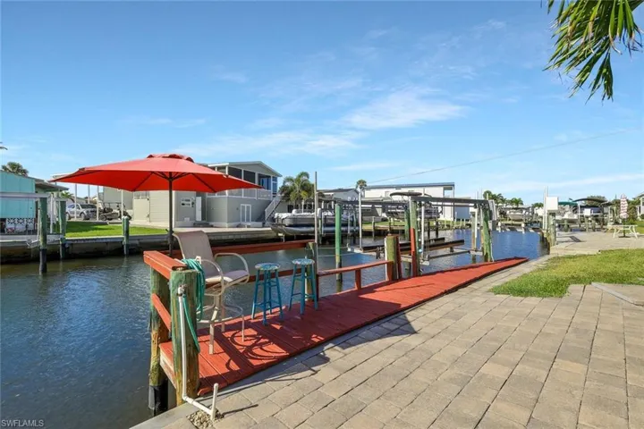 View of dock with a water view, a residential view, and boat lift