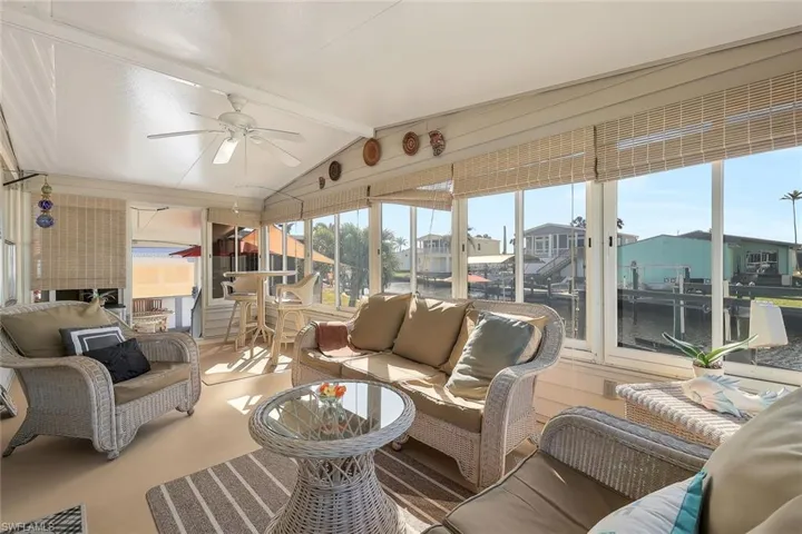 Sunroom featuring an outdoor living space, beamed ceiling, and a ceiling fan