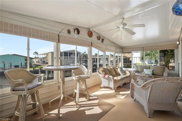 Sunroom / solarium featuring vaulted ceiling with beams
