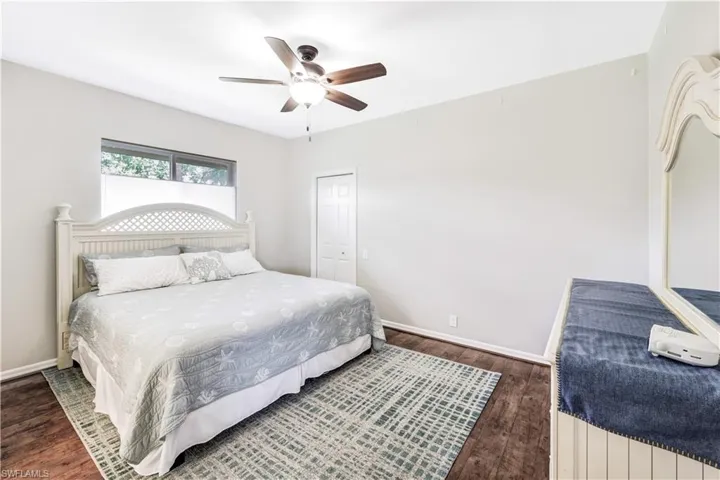 Bedroom with dark wood-type flooring and ceiling fan