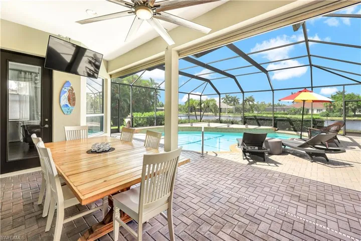 View of swimming pool featuring a patio area, ceiling fan, and a lanai