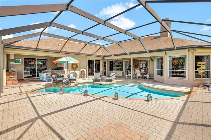 View of swimming pool featuring glass enclosure and a patio