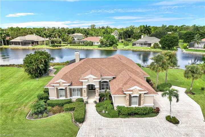 View of front facade with a water view and a front lawn