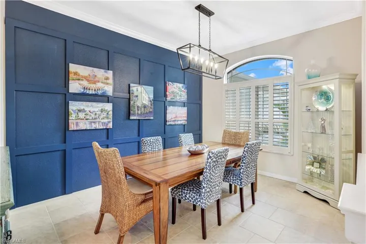 Dining room featuring ornamental molding, a notable chandelier, and light tile patterned flooring