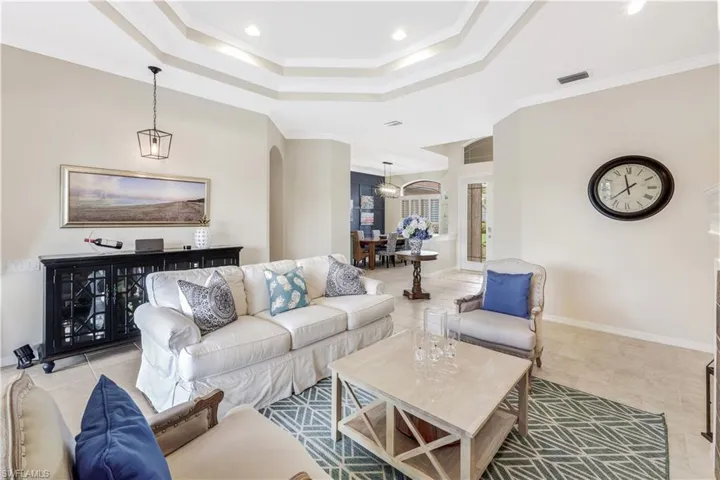 Tiled living room with a tray ceiling and ornamental molding