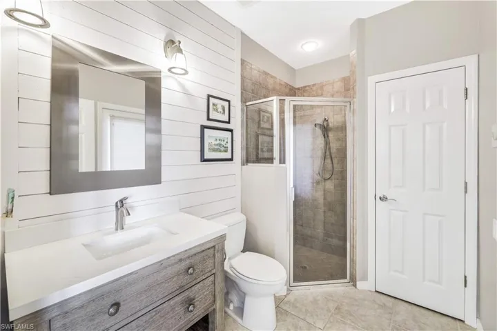 Bathroom with vanity, toilet, tile patterned floors, and walk in shower