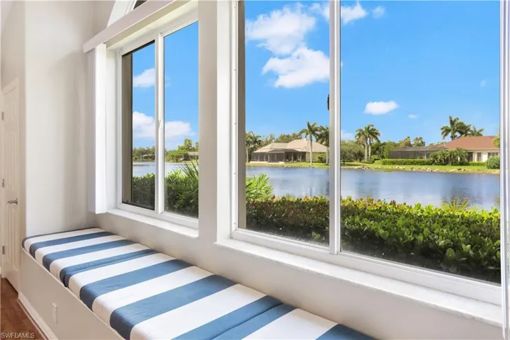 Unfurnished bedroom featuring hardwood / wood-style flooring and a water view
