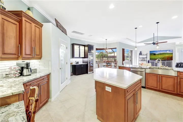 Kitchen with ceiling fan, sink, tasteful backsplash, and light tile patterned flooring