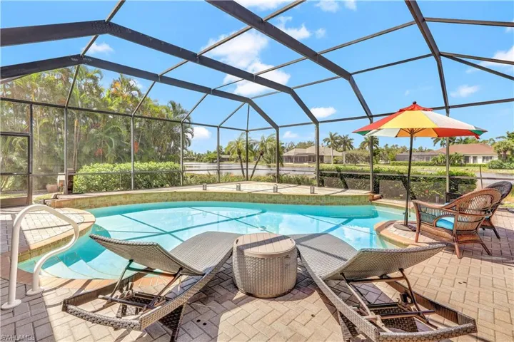 View of swimming pool featuring glass enclosure and a patio area