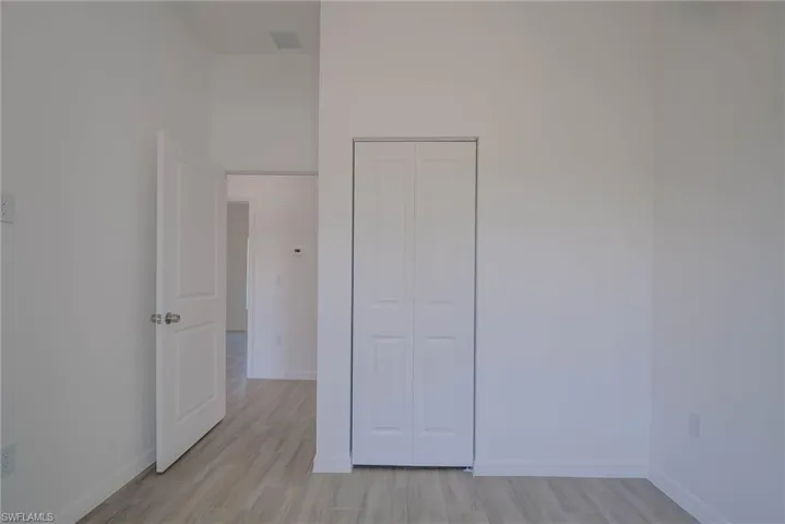 Spare room with visible vents, baseboards, and light wood-style flooring