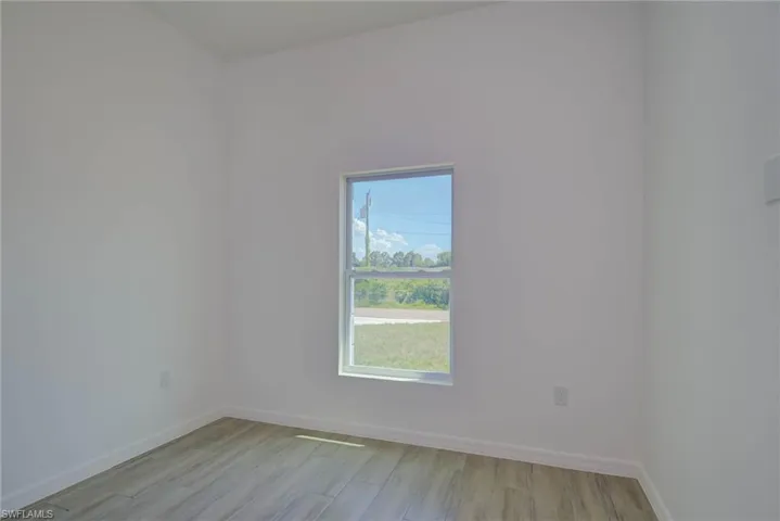 Unfurnished room featuring baseboards and light wood finished floors
