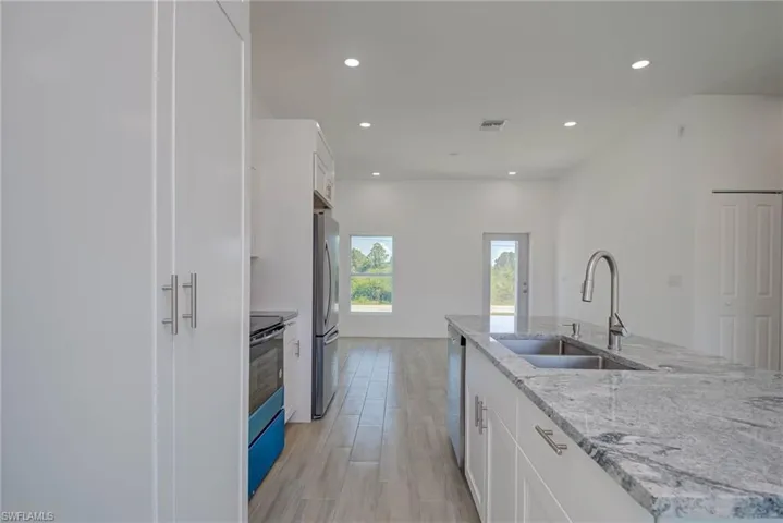 Kitchen featuring recessed lighting, white cabinetry, a sink, and appliances with stainless steel finishes