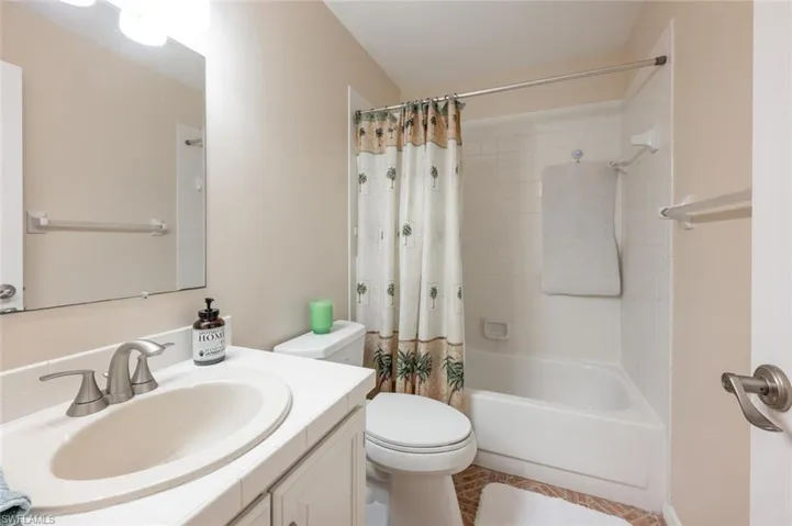 Guest bathroom featuring vanity, shower / bath combo, and toilet