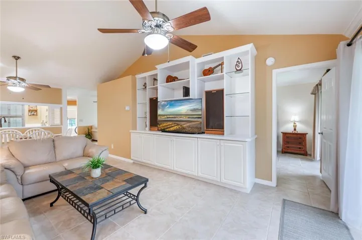 Tiled living room featuring lofted ceiling
