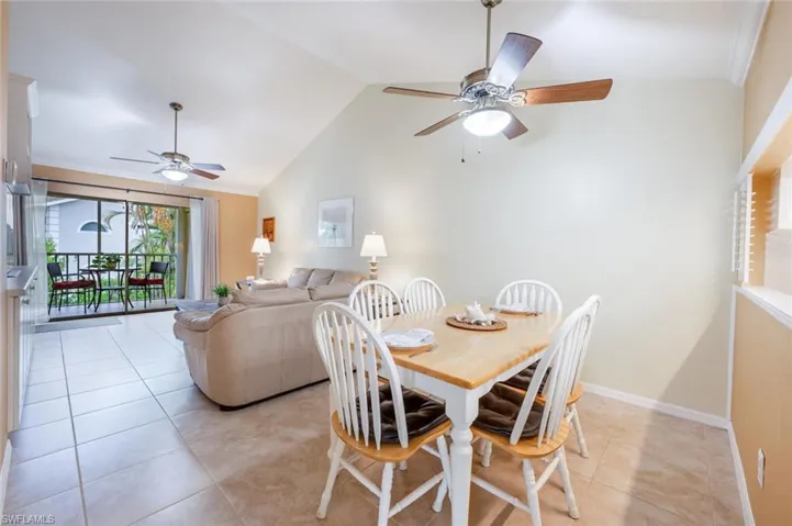Tiled dining room featuring high vaulted ceiling