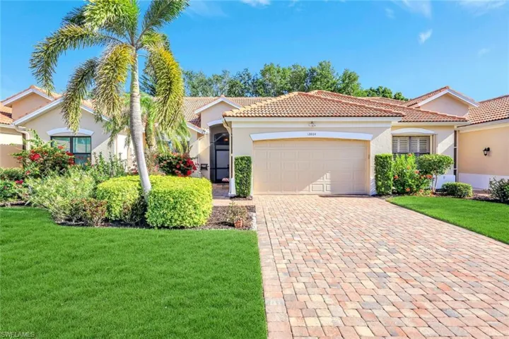 Mediterranean / spanish-style home with a front lawn, a tile roof, decorative driveway, and stucco siding