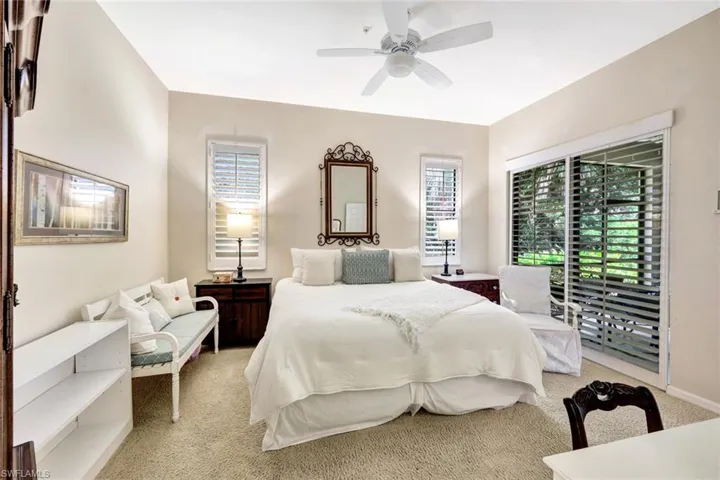 Bedroom featuring light colored carpet, access to exterior, and a ceiling fan