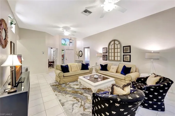 Tiled living area featuring visible vents and ceiling fan