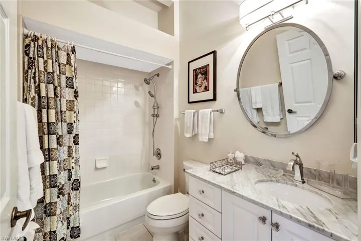 Full bathroom with toilet, shower / bath combination with curtain, tile patterned floors, and vanity
