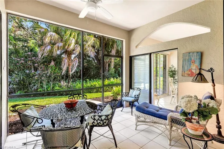 Sunroom with tile patterned floors and a textured wall