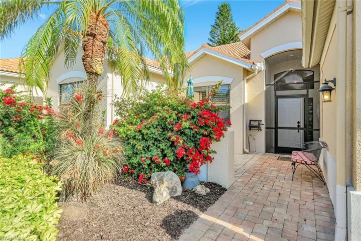 View of exterior entry with a tile roof and stucco siding