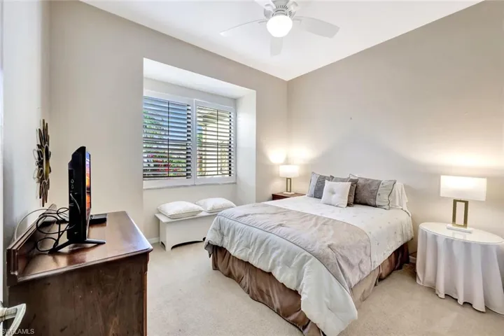 Bedroom featuring baseboards, light colored carpet, and ceiling fan