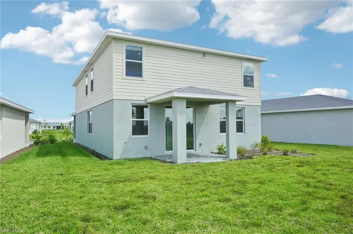 Rear view of house featuring a patio and a yard