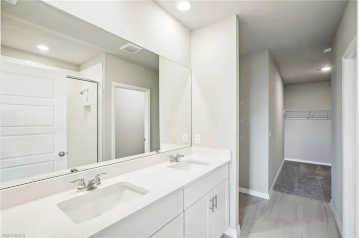 Bathroom featuring a shower with door and vanity