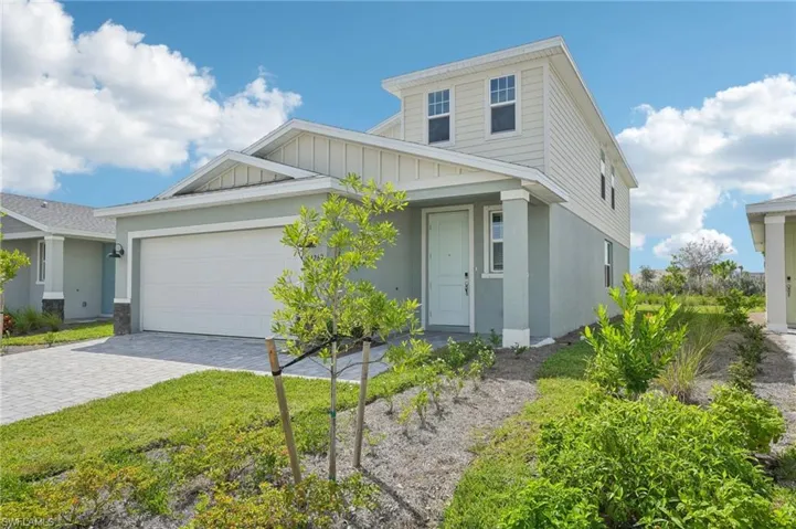View of front of house featuring a front yard and a garage
