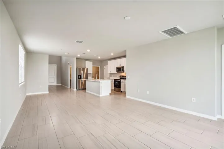 Unfurnished living room featuring light hardwood / wood-style flooring and sink