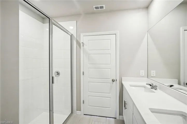 Bathroom featuring vanity and an enclosed shower