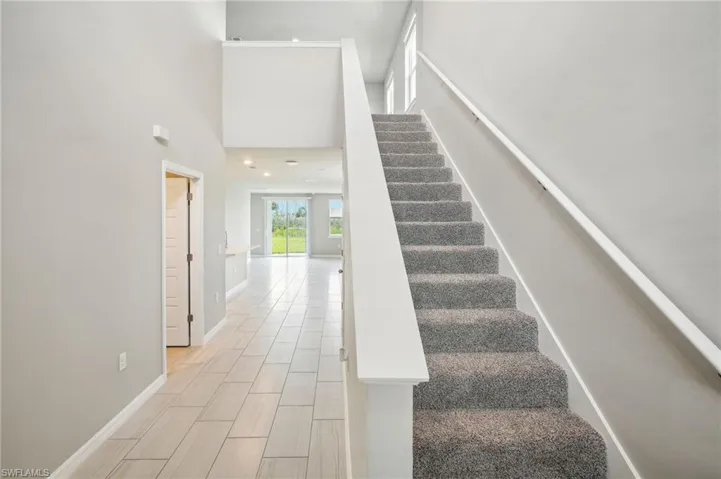 Staircase featuring a towering ceiling
