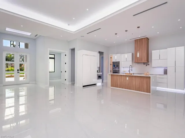Kitchen featuring pendant lighting, a large island, light countertops, white cabinets, and modern cabinets