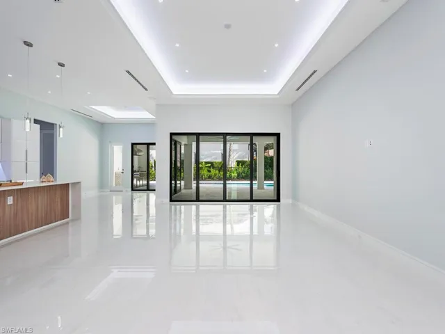 Empty room with baseboards and a raised ceiling