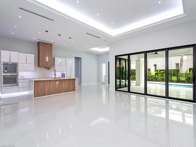 Kitchen with white cabinets, light countertops, hanging light fixtures, a center island, and modern cabinets