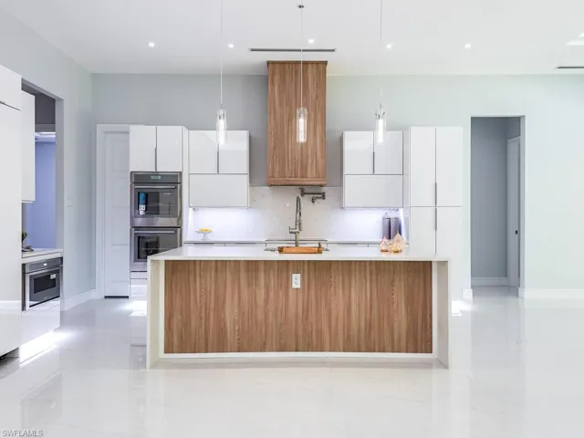 Kitchen with light countertops, modern cabinets, a sink, and white cabinets
