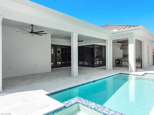 View of pool featuring a ceiling fan, exterior kitchen, and a patio