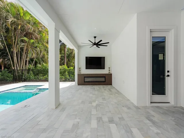 View of swimming pool with a patio, a pool with connected hot tub, fence, and a ceiling fan
