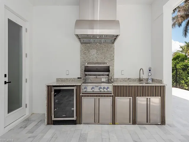 View of patio / terrace with beverage cooler, grilling area, an outdoor kitchen, and a sink