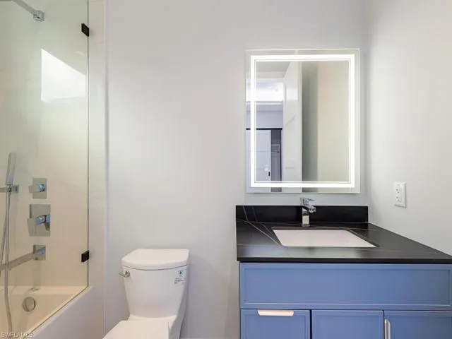 Full bathroom featuring toilet, vanity, and washtub / shower combination