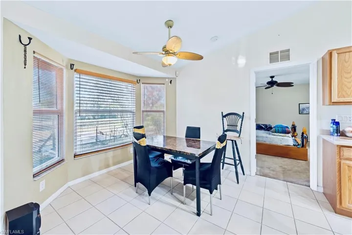 Dining space with visible vents, baseboards, ceiling fan, and light tile patterned flooring
