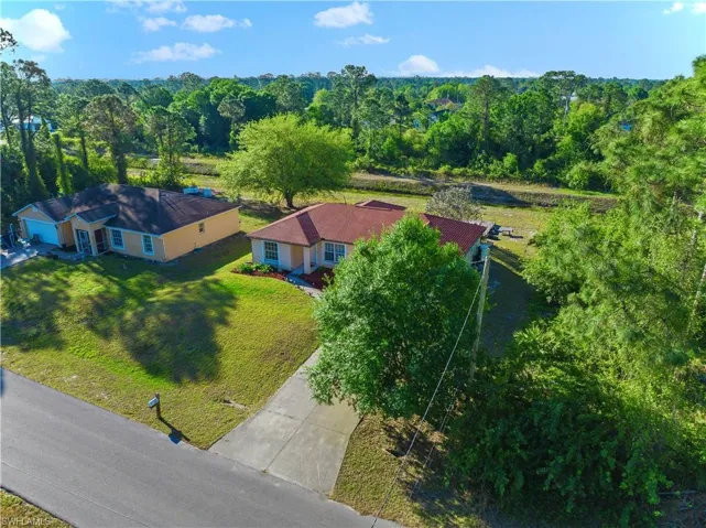 Birds eye view of property featuring a wooded view