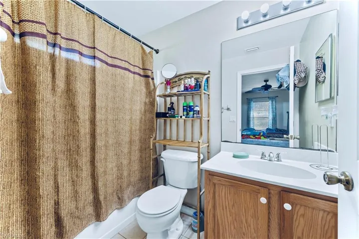 Full bath with vanity, toilet, shower / bath combo with shower curtain, and ensuite bathroom