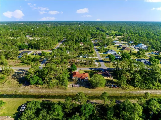 Birds eye view of property with a wooded view