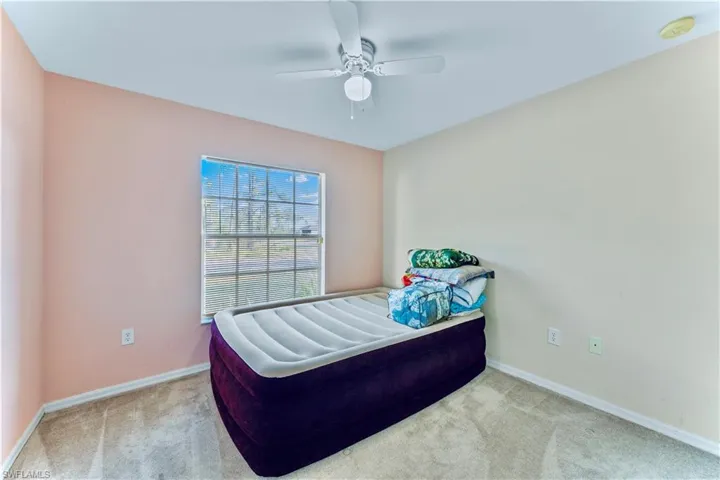 Carpeted bedroom featuring a ceiling fan and baseboards